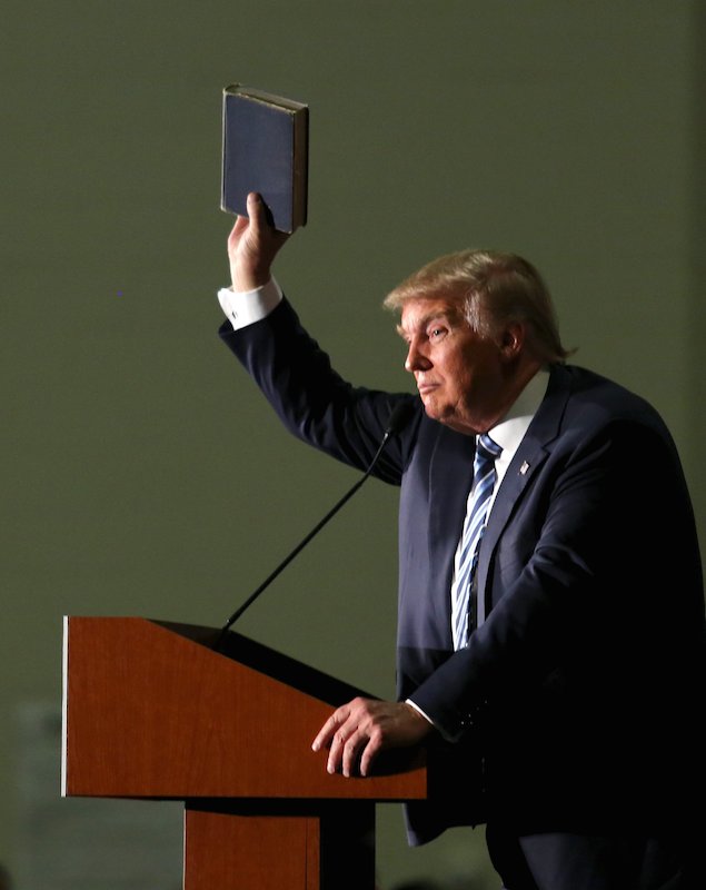 U.S. Republican presidential candidate Trump holds up a copy of the Bible he said his mother gave him as a youth during a campaign rally in Council Bluffs
