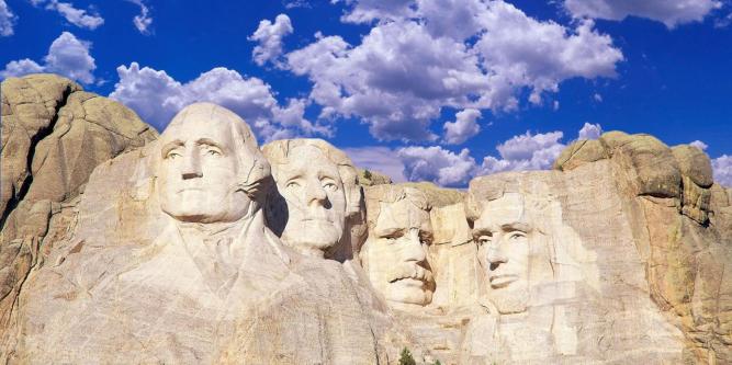 Composite image of Mount Rushmore and blue sky with white clouds
